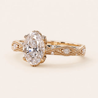 Oval Lab Grown Diamond vintage engagement ring in yellow gold with an Art Deco infinity shank, marquise and round diamond accents, and milgrain detailing.