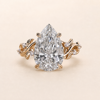 Pear cut lab grown diamond cluster engagement ring in yellow gold with sculptural leaf-and-vine shoulders