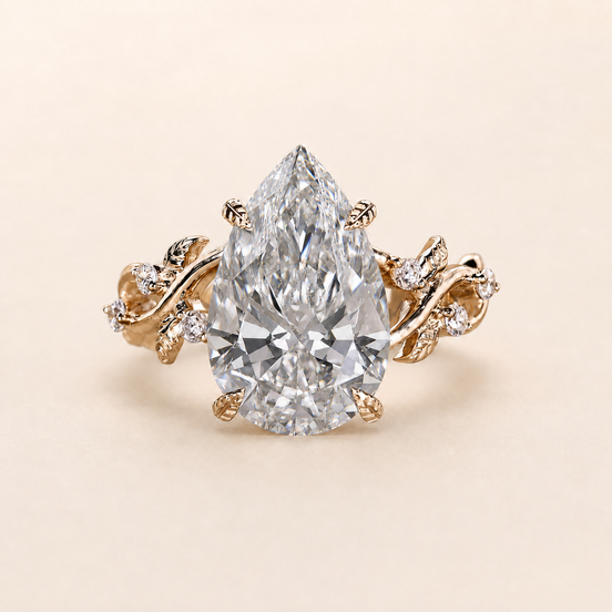 Pear cut lab grown diamond cluster engagement ring in yellow gold with sculptural leaf-and-vine shoulders
