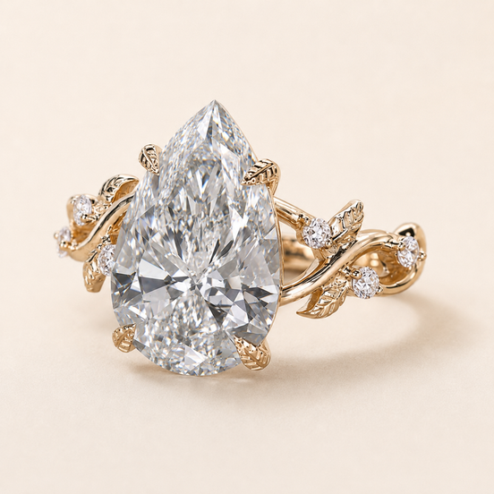 Pear cut lab grown diamond cluster engagement ring in yellow gold with sculptural leaf-and-vine shoulders