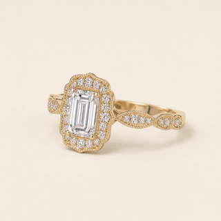 Emerald cut lab grown diamond halo engagement ring in yellow gold with rectangular pavé halo and twisted shoulders