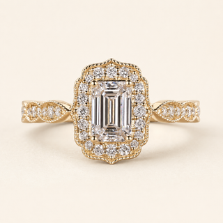 Emerald cut lab grown diamond halo engagement ring in yellow gold with rectangular pavé halo and twisted shoulders