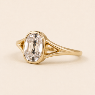 Cushion cut lab grown diamond bezel engagement ring in yellow gold with open split-shank shoulders