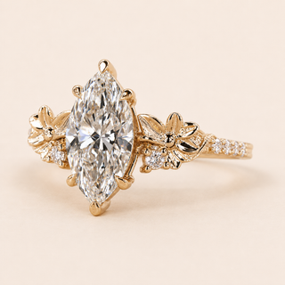 Marquise cut lab grown diamond floral engagement ring in yellow gold with sculptural flower-and-leaf shoulders