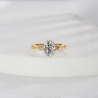 val cut lab grown diamond side stone engagement ring in yellow gold with round bezel accents and sculpted shoulders
