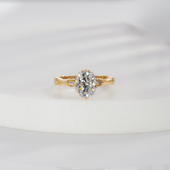 val cut lab grown diamond side stone engagement ring in yellow gold with round bezel accents and sculpted shoulders