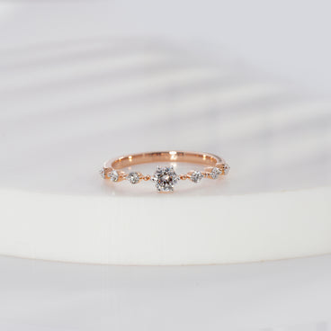 Round cut lab grown diamond side stone engagement ring in rose gold with graduated round diamond shoulders