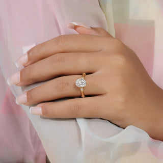 val cut lab grown diamond side stone engagement ring in yellow gold with round bezel accents and sculpted shoulders