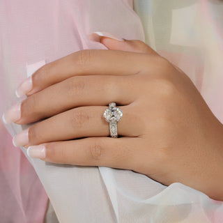 Oval cut lab grown diamond vintage engagement ring in white gold with marquise and round diamond accents and milgrain scrollwork