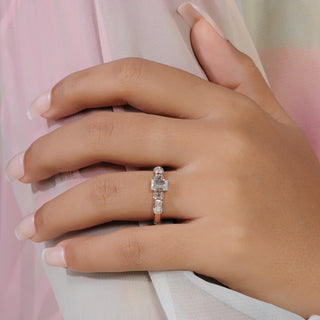 Emerald cut lab grown diamond side stone engagement ring in yellow gold with baguette and round diamond shoulders