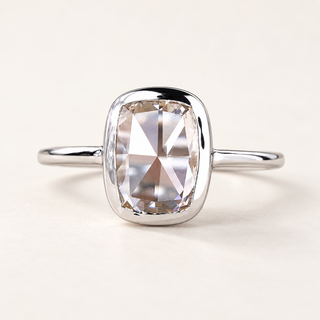 Elongated cushion rose cut lab grown diamond bezel engagement ring in white gold with a broad rounded rim and plain polished band