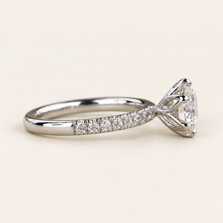 Round lab grown diamond six-prong engagement ring in white gold with pavé-set shoulders and raised center