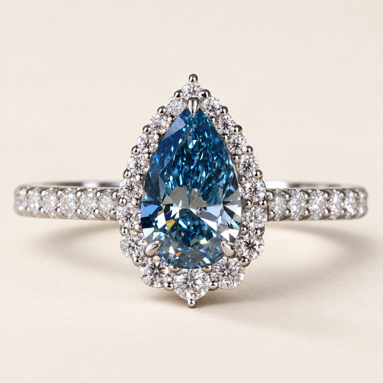 Blue pear cut lab grown diamond halo engagement ring in white gold with three center prongs, round diamond surround and pavé shoulders