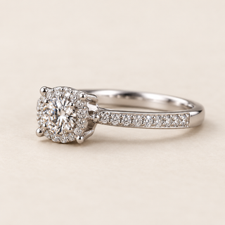 Round lab grown diamond pavé halo engagement ring in white gold with polished prongs and diamond-set shoulders