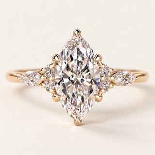 Marquise cut lab grown diamond cluster engagement ring with pointed center, pear-shaped marquise side diamonds, round accents and polished yellow gold band.