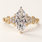 Marquise cut lab grown diamond engagement ring with a 2 ct center, protective tip prongs, six round diamond accents and leaf-and-vine yellow gold shoulders.