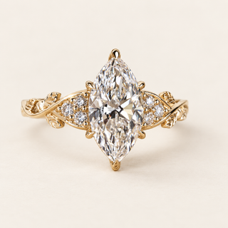 Marquise cut lab grown diamond engagement ring with a 2 ct center, protective tip prongs, six round diamond accents and leaf-and-vine yellow gold shoulders.