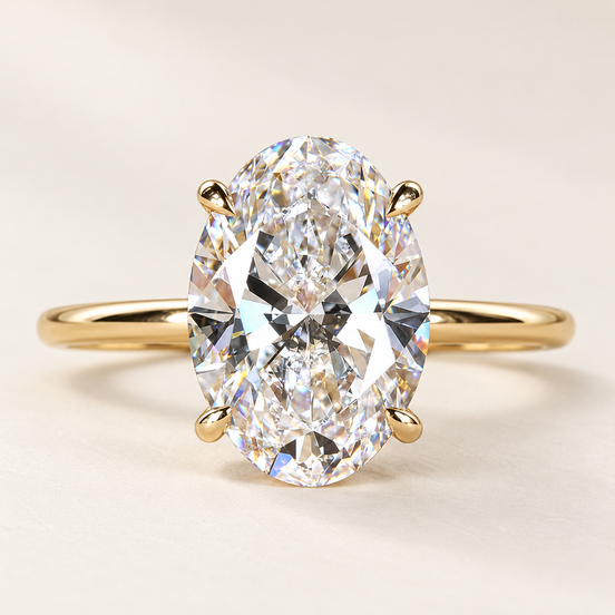 Oval cut lab grown diamond four-prong engagement ring in yellow gold with individual claw tips and a plain polished band