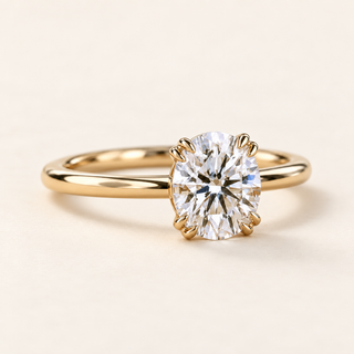 Round lab grown diamond engagement ring in yellow gold with eight prongs arranged in four pairs and a plain polished band