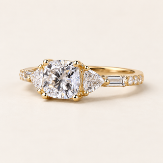 Cushion cut lab grown diamond three-stone engagement ring with 1.00 ct center, trillion side diamonds, baguette accents and polished yellow gold band.