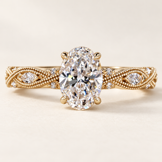 Oval cut lab grown diamond engagement ring with 1.00 ct center, marquise diamond leaf motifs, milgrain detailing and hidden halo in yellow gold.