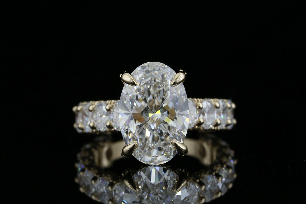 Yellow gold ring with 6.25ct oval lab grown diamond and oval diamond band on black