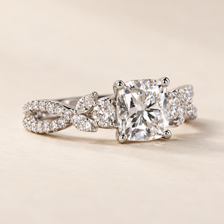 Cushion cut lab grown diamond engagement ring with 1.50 ct center, marquise and round diamond trellis shoulders, four-prong setting and polished white gold band.
