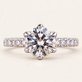 Round lab grown diamond six-prong engagement ring in white gold with pavé-set shoulders and raised center