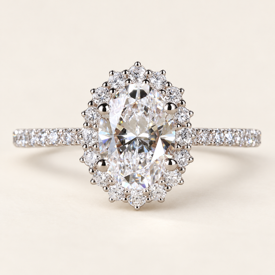 Oval cut lab grown diamond halo engagement ring in white gold with scalloped round diamond halo, pavé shoulders and raised center prongs.