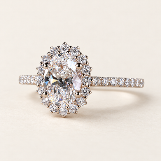 Oval cut lab grown diamond halo engagement ring in white gold with scalloped round diamond halo, pavé shoulders and raised center prongs.
