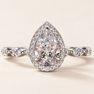 Pear cut lab grown diamond halo engagement ring in white gold with pavé halo and floating marquise side diamonds