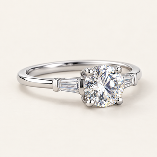 Round cut lab grown diamond three-stone engagement ring in white gold with tapered baguette side diamonds and polished band