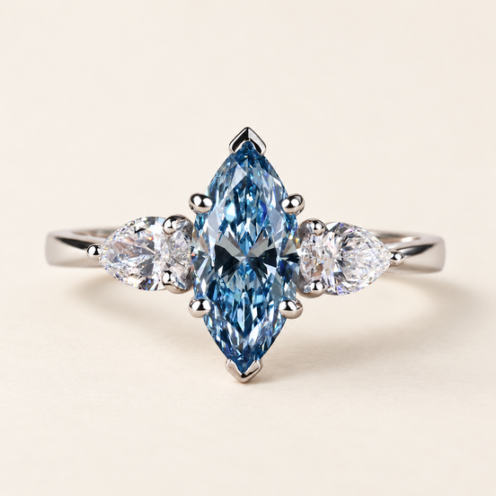 Blue marquise lab grown diamond three-stone engagement ring in white gold with V-shaped tip guards and outward-pointing pear side diamonds