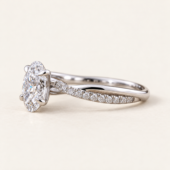 Oval cut lab grown diamond crossover engagement ring in white gold with four-prong center, twisted pavé shoulders and polished band