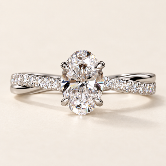 Oval cut lab grown diamond crossover engagement ring in white gold with four-prong center, twisted pavé shoulders and polished band