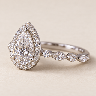 Pear cut lab grown diamond halo engagement ring in white gold with pavé halo and floating marquise side diamonds