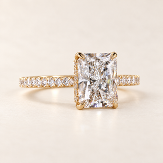 Radiant cut lab grown diamond engagement ring with 3 ct center stone, four-prong basket and pavé diamond band in yellow gold, front view.
