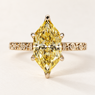 Fancy yellow Dutch marquise cut lab grown diamond engagement ring with protective pointed-end prongs, engraved floral shoulders and milgrain detailing in polished yellow gold.