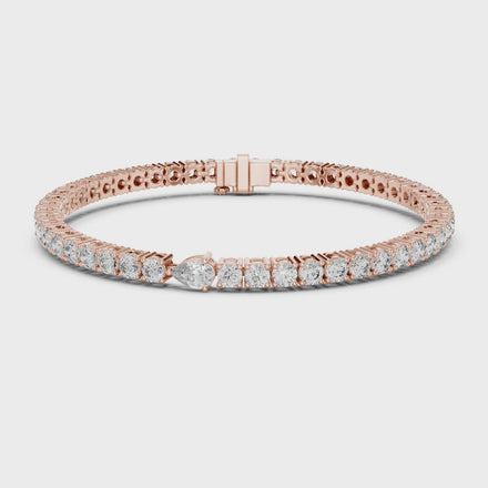 Pear accent lab grown diamond tennis bracelet with round diamonds and central pear cut diamond in gold variations