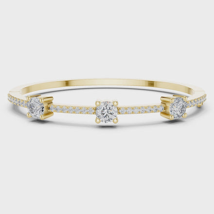 Elegant three stone round diamond bangle bracelet in gold with pavé accent diamonds by Signora Jewels