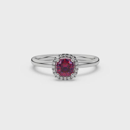 Red cushion cut gemstone halo ring with diamond accents in gold