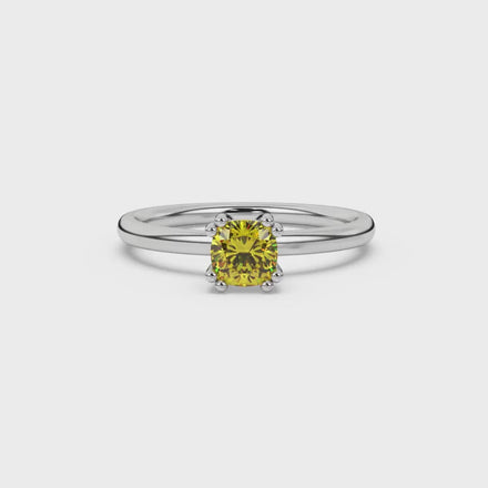 Yellow cushion cut solitaire gemstone ring in six-prong gold setting with slim stackable band