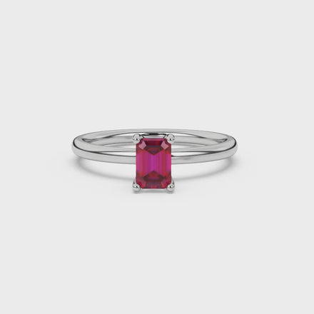 Emerald cut red gemstone solitaire ring in gold four prong setting