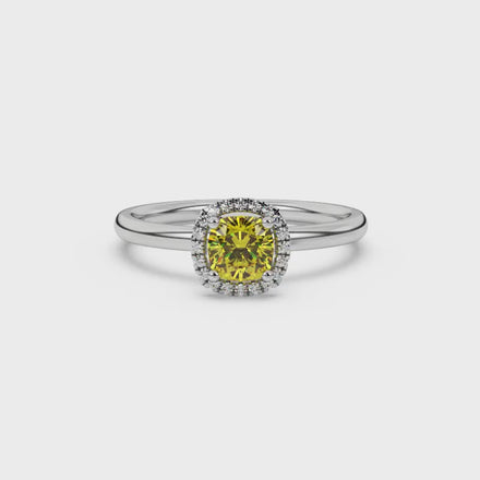 Yellow cushion cut gemstone halo ring with diamond accents in gold