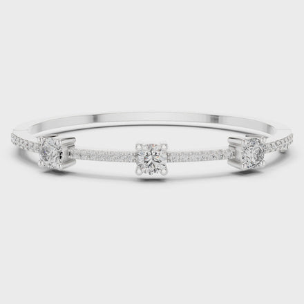 Elegant three stone round diamond bangle bracelet in gold with pavé accent diamonds by Signora Jewels