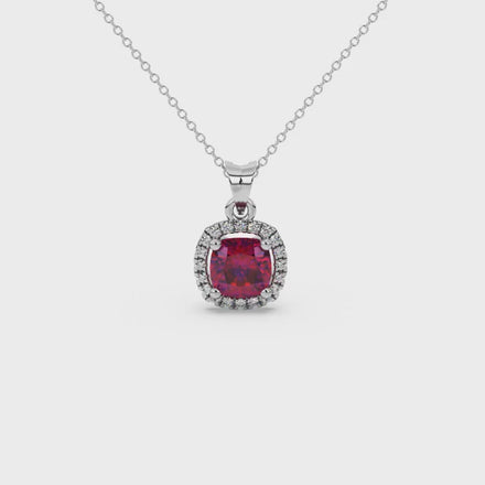 Red cushion cut gemstone halo pendant with diamond accents in gold