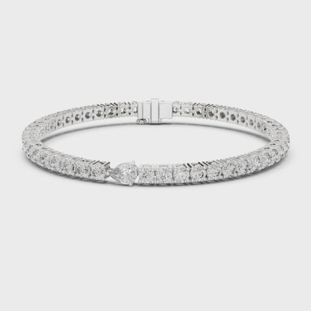 Pear accent lab grown diamond tennis bracelet with round diamonds and central pear cut diamond in gold variations