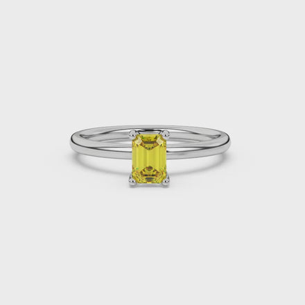 Emerald cut yellow gemstone solitaire ring in gold four prong setting