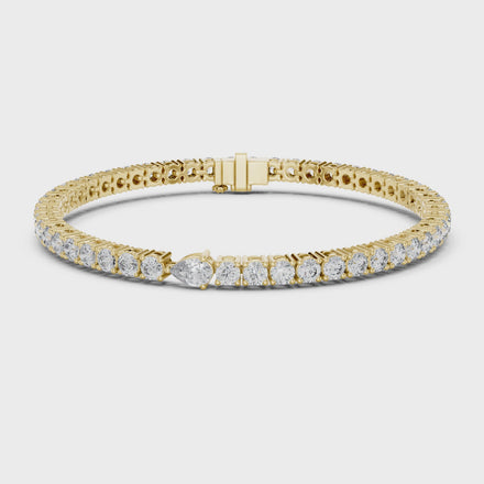 Pear accent lab grown diamond tennis bracelet with round diamonds and central pear cut diamond in gold variations