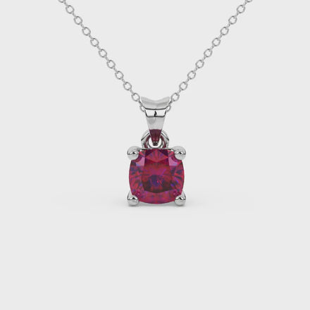 Red cushion cut gemstone solitaire pendant in gold featuring a refined four-prong basket setting